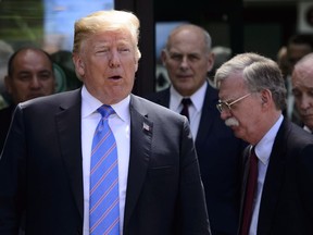 U.S. President Donald Trump leaves the G7 Leaders Summit in La Malbaie, Que., on Saturday, June 9, 2018., with his team Larry Kudlow, from right, John Bolton, and John Kelly.