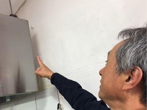 Dong Won Kang points to a spot on the wall where he says a stray bullet entered his sushi restaurant, two doors down from where Ottawa police say a man fired several shots inside a pizza shop Saturday night. Photo: Matthew Pearson