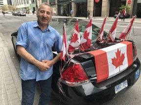 Cabbie Saleh Ali wears his patriotism on his sleeve, or at least, his cab.  Blair Crawford/Postmedia  0628 cabbie