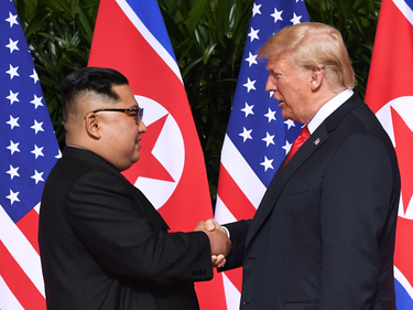 North Korean leader Kim Jong Un and U.S. President Donald Trump shake hands at the start of their historic summit, at the Capella Hotel on Sentosa island in Singapore on June 12, 2018.