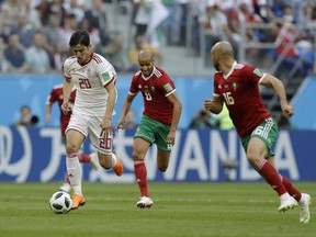 Iran's Sardar Azmoun, left, and Morocco's Noureddine Amrabat, right, compete for the ball during the group B match between Morocco and Iran at the 2018 soccer World Cup in the St. Petersburg Stadium in St. Petersburg, Russia, Friday, June 15, 2018.