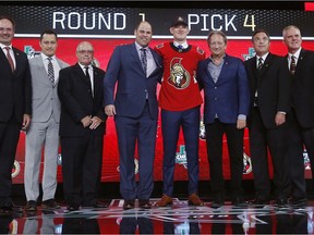 Brady Tkachuk, centre poses after being selected by the Ottawa Senators during the NHL hockey draft in Dallas, Friday, June 22, 2018.