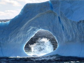 An iceberg is seen in Amherst Cove, N.L. on June 4, 2018 in this handout photo. An unusually shaped iceberg is drawing onlookers to a small cove in eastern Newfoundland. The iceberg has a hollow archway carved in the middle and appears to be grounded in the waters just off a Bonavista peninsula community in Upper Amherst Cove.