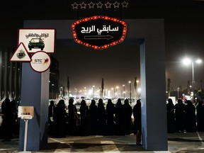 In photo taken June 22, 2018 photo, women wait in line to ride go carts at a road safety event for female drivers launched at the Riyadh Park Mall in Saudi Arabia.