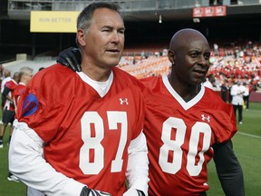 In this July 12, 2014, file photo, former San Francisco 49ers wide receivers Dwight Clark, left, and Jerry Rice, right, walk together on the field in San Francisco.