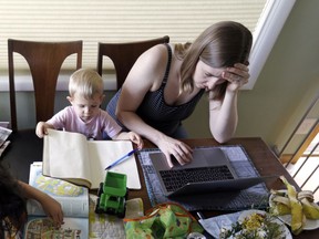 In this Wednesday, June 27, 2018, photo, Caely Barrett, who is part of a small group of stay-at-home mothers working to organize an immigration rally, works on her laptop next to her 18-month-old son in Portland, Ore. The small group of mothers organizing Saturday's rally in Portland to coincide with Families Belong Together rallies nationwide, are working almost around-the-clock to pull together an event expected to attract 5,000 people.