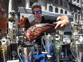 Neal Moore from Gator BBQ hold up two racks of ribs in Ottawa Wednesday June 20, 2018. Neal and his family are taking part in the Ottawa Ribfest which is taking place on Sparks Street in Ottawa from June 20-24.