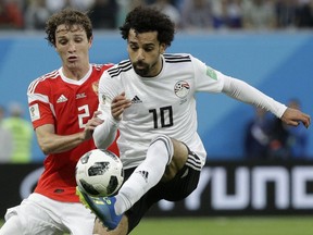 Russia's Mario Fernandes, left, challenges for the ball Egypt's Mohamed Salah, right, during the group A match between Russia and Egypt at the 2018 soccer World Cup in the St. Petersburg stadium in St. Petersburg, Russia, Tuesday, June 19, 2018.