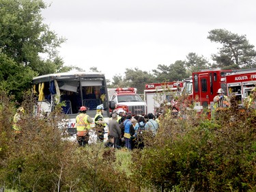 Firefighters help passengers of a bus involved in a serious collision west of Prescott on Highway 401 on Monday, June 4, 2018 near Prescott, Ont.