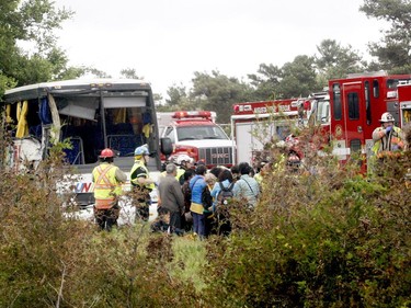 Firefighters help passengers of a bus involved in a serious collision west of Prescott on Highway 401 on Monday, June 4, 2018 near Prescott, Ont. (MARSHALL HEALEY/Special to The Recorder and Times)