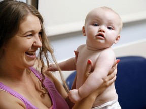 In this July 13, 2017 photo, Stephanie Gaffney bounces her daughter, Elliana, when she was 8 months old and visiting the neonatal-abstinence syndrome clinic at Cincinnati Children's Hospital Medical Center. The Cincinnati Enquirer is donating $5,000 of its 2018 Pulitzer Prize for local reporting to benefit Elliana featured in the newspaper's winning report on heroin. Gaffney died of an overdose of a fentanyl combination 10 days after speaking with the newspaper for the story.