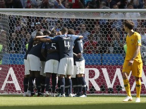 Members of the French team mob France's Antoine Griezmann after he scored the opening goal from the penalty spot during the group C match between France and Australia at the 2018 soccer World Cup in the Kazan Arena in Kazan, Russia, Saturday, June 16, 2018.