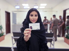 This image released by the Saudi Information Ministry shows Esraa Albuti as she displays her brand new driving license at the General Department of Traffic in the capital, Riyadh, Monday, June 4, 2018.