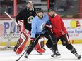Injured defenceman Chris Wideman (L), wearing a non-contact sweater, and Frederik Claesson battle for position in front of the net during a Senators practice in March. Wayne Cuddington/Postmedia