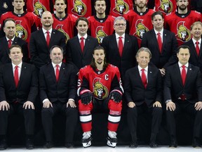 NHL Ottawa Senators captain Erik Karlsson sits alongside team owner Eugene Melnyk, second from left, as they take part in the annual team photo in Ottawa on Wednesday, March 7, 2018.