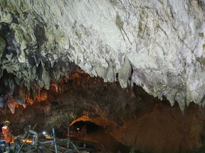 A rescuer works at the entrance to a cave complex where 12 soccer team members and their coach went missing, in Mae Sai, Chiang Rai province, in northern Thailand Saturday, June 30, 2018. Rescuers have been searching for them.