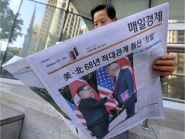 A man reads a newspaper reporting the summit between U.S. President Donald Trump and North Korean leader Kim Jong Un, at a newspaper distributing station in Seoul, South Korea, Tuesday, June 12, 2018. The headline read: " North Korea and the United States end 68 years of hostile relations."