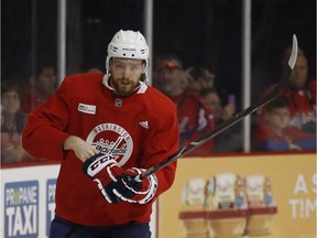 Centre Evgeny Kuznetsov puts on his glove as he takes the ice for practice in Arlington, Va., on Friday. Kuznetsov left Game 2 against the Golden Knights on Wednesday early because an apparent arm injury.