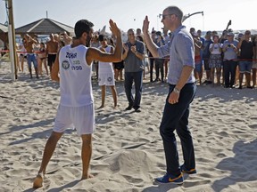 Britain's Prince William high-fives a beach volleyball player during a visit with Ron Huldai, the Mayor of Tel Aviv, in the coastal Mediterranean city of Tel Aviv, Israel, Tuesday, June 26, 2018. The prince is the first member of the British royal family to pay an official visit to Israel. Though the trip is being billed as non-political, the prince is meeting with Israeli and Palestinian leaders and visiting sites at the heart of the century-old conflict.