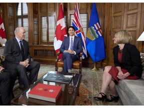 Prime Minister Justin Trudeau, B.C. Premier John Horgan, left, and Alberta Premier Rachel Notley, sit in Trudeau's office on Parliament Hill for a meeting on the deadlock over Kinder Morgan's Trans Mountain pipeline expansion, in Ottawa on Sunday, April 15, 2018. Different provinces see the climate change challenge in very different ways.