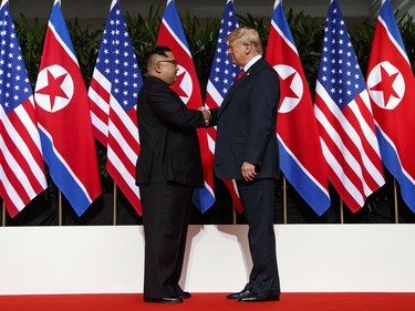 North Korean leader Kim Jong Un, left, and U.S. President Donald Trump shake hands prior to their meeting on Sentosa Island in Singapore Tuesday, June 12, 2018. Kim is about 170 centimeters (5.8 feet) tall, about 20 centimeters (7.2 inches) shorter than Trump, according to media reports. But when the two stood together during Tuesday's meeting, the difference in their heights wasn't that noticeable.
