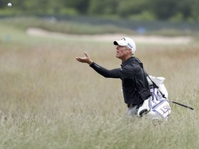 Luis Gagne's caddie turns to catch a ball as he walks through the fescue during a practice round for the U.S. Open Golf Championship, Wednesday, June 13, 2018, in Southampton, N.Y.