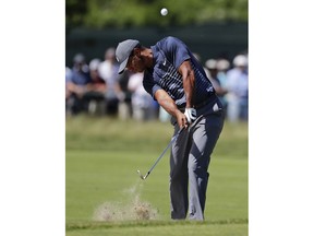 Tiger Woods hits an approach shot on the fourth hole during the first round of the U.S. Open Golf Championship, Thursday, June 14, 2018, in Southampton, N.Y.