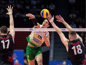 Luke Smith of Australia spikes the ball while Canadians Graham Vigrass (L) and Bradley Robert Gunter try to block it during Canada vs Australia match at the FIVB Volleyball Nations League tournament held at TD Place in Ottawa.  Photo by Wayne Cuddington/ Postmedia