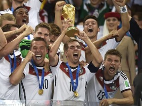 FILE - In this July 13, 2014, file photo, Germany's Philipp Lahm (16) raises the trophy after the World Cup final soccer match between Germany and Argentina at the Maracana Stadium in Rio de Janeiro, Brazil. After raising the World Cup eight miles from Copacabana Beach four years ago, Germany hopes to lift the trophy four miles from the Kremlin on July 15 and become the first repeat champion in more than a half-century.