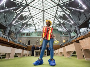 Construction cleaner Tigest Asefa, wearing protective coverings on her boots to protect the carpets, gets a look at the new House of Commons as the media gets a tour of the West Block on Parliament Hill to observe the construction as it begins to near the end. Members of Parliament will begin sitting in the new House of Commons sometime in January 2019.