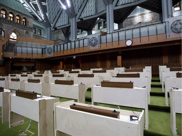 Desks, including the desk where the Prime Minister is expected to sit, centre, are seen in the interim House of Commons Chamber during a media tour of the renovated West Block on Parliament Hill in Ottawa on Friday, June 15, 2018. The plywood desks are temporary furnishings for the purpose of preparing each desk's electronic equipment in advance of the actual desks, which will be brought in from existing House of Commons
