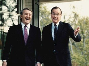 This 1988 file photo shows Vice President George Bush with Prime Minister Brian Mulroney, following a question from a reporter outside Bush's residence in Washington, DC.