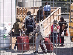 A group of asylum seekers arrives at the temporary housing facilities at the border crossing Wednesday May 9, 2018 in St. Bernard-de-Lacolle, Que.