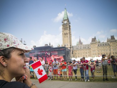 Canada Day celebrations took over the downtown core of Ottawa Sunday July 1, 2018. Ali Iranpour holds a Canada flag awaiting the dignitaries arrival on Parliament Hill prior to the noon show.