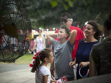 People enjoy a fan blowing cool water in Majors Hill Park on Sunday.   Ashley Fraser/Postmedia