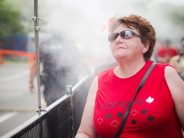 Cécile Levert enjoys a cool mist after the security screening on her way to Parliament Hill.   Ashley Fraser/Postmedia