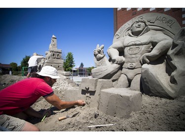 Martin Ernst works on his sand sculpture Saturday.