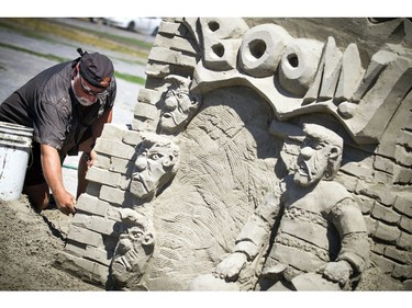 Mike Beaupre works on his sand sculpture Saturday.