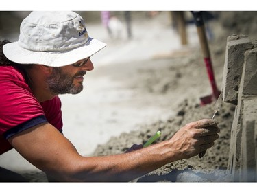 Martin Ernst works on his sand sculpture Saturday.