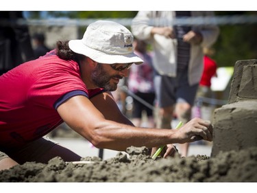 Martin Ernst works on his sand sculpture Saturday.