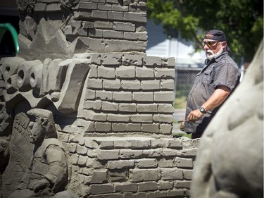 Mike Beaupre works on his sand sculpture Saturday.