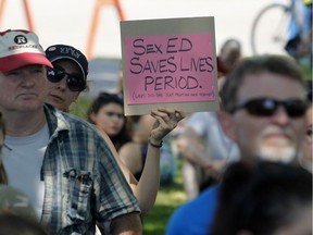 People gather to protest changes to Ontario's sex-ed curriculum at the Human Rights Monument in Ottawa on Sunday.
