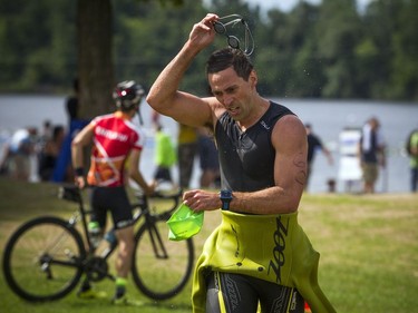 The 37th Annual National Capital Triathlon took place Saturday July 28, 2018 at Mooney's Bay and the surrounding area. Craig Burkett pulls off his swim gear as he makes his way to his bike.   Ashley Fraser/Postmedia