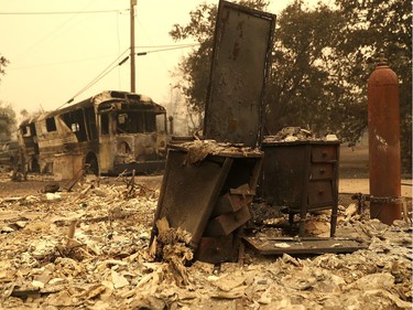 REDDING, CA - JULY 28:  A bus and a vanity sit in the rubble of a home destroyed by the Carr Fire on July 28, 2018 in Redding, California. A Redding firefighter and a bulldozer operator were killed battling the fast moving Carr Fire that has burned over 80,000 acres and destroyed hundreds of homes. The fire is 5 percent contained.