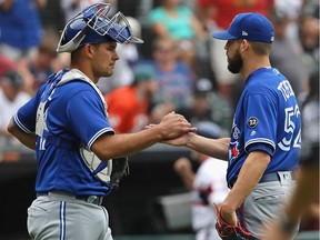 Luke Maile #21 (L) and Ryan Tepera #52 of the Toronto Blue Jays celebrate a win over the Chicago White Sox at Guaranteed Rate Field on July 29, 2018 in Chicago, Illinois. The Blue Jays defeated the White Sox 7-4.