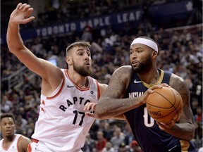 Toronto Raptors centre Jonas Valanciunas looks to block now former New Orleans Pelicans centre DeMarcus Cousins.