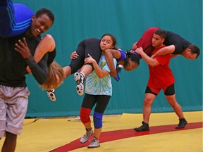 Ahmed Mohamed (L) carries Coach Sarah Stringer, Jessica Hong (M), Sir Robert Borden, girls' 44 kilograms carries Bailey Agard and Ismail Ayyoub (R), Longfields-Davidson Heights, boys' 83 kilograms carries Joe Greer during wrestling practice St. Patrick's HS in Ottawa, May16, 2018.  Photo by Jean Levac/Postmedia  129217