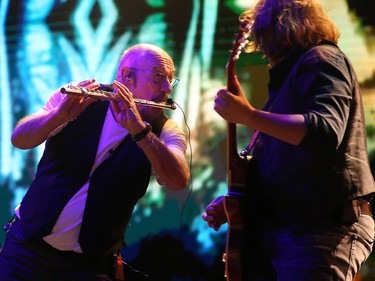 Jethro Tull's Ian Anderson, who is a founding member of the 50-year-old band, plays against a psychedelic backdrop of old TV footage on the main stage at Bluesfest on Friday, July 6, 2018.