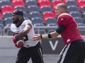 Ottawa Redblacks QB Trevor Harris hands off to RB William Powell during team practice at TD Place on Monday July 16, 2018.