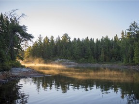 Rock shoreline of the Canadian Shield, still waters in the early morning light,
Lake Temagami.